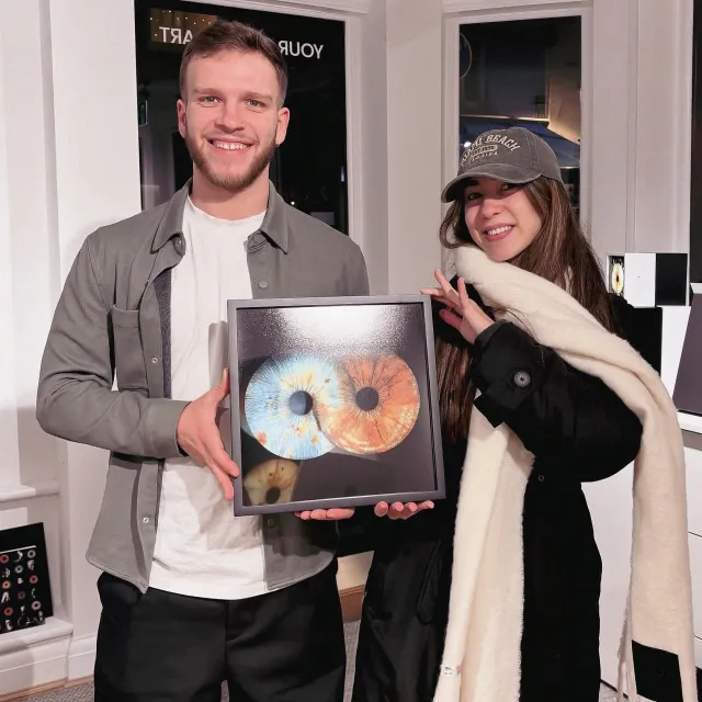A couple holding their framed iris artwork