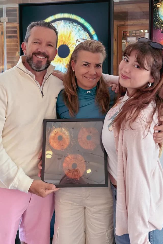 A family holding their framed iris artwork