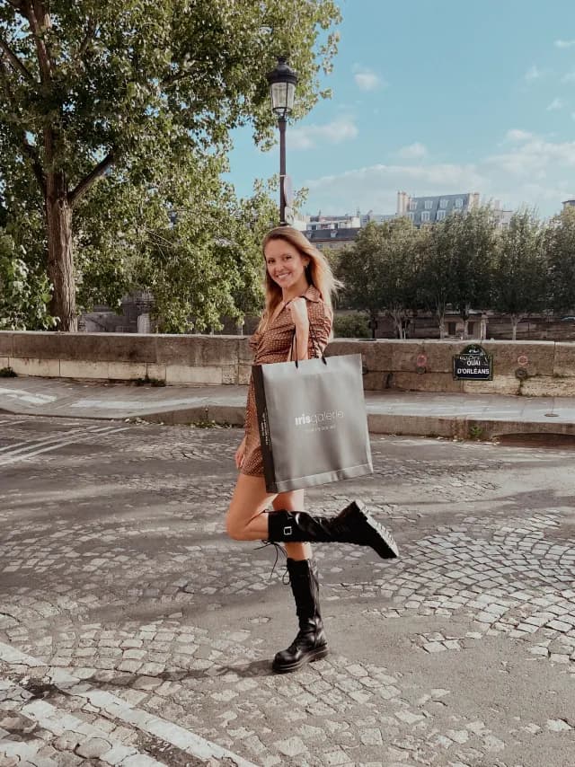 A woman outdoors with her Iris Galerie shopping bag